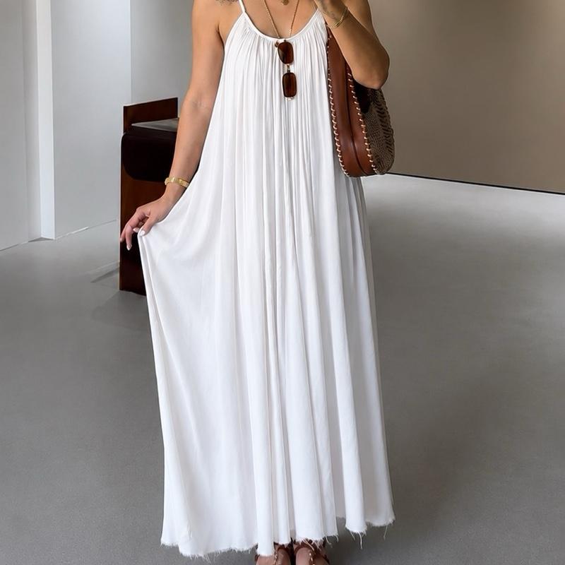Femme portant une robe longue blanche fluide à fines bretelles avec coupe ample et tombé aérien.