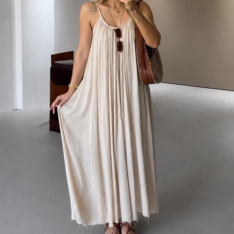 Femme portant une robe longue écrue fluide à fines bretelles avec coupe ample et tombé léger.